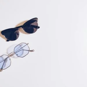 Flat lay of sunglasses and eyeglasses on a white background, perfect for fashion design concepts.